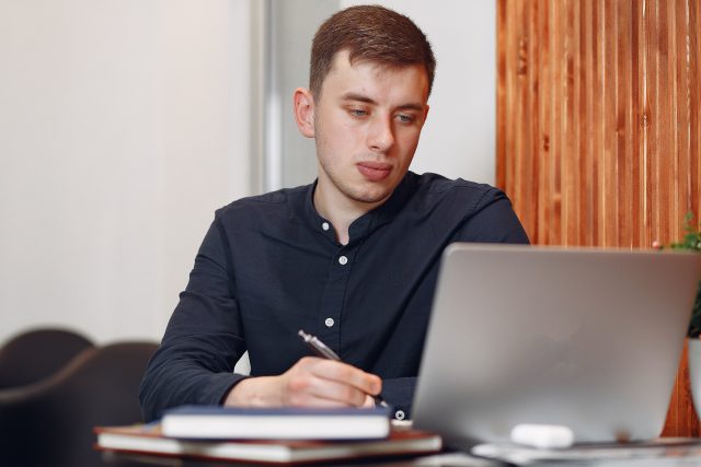 Stylish businessman working in a office and use the laptop